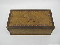 Top view showing marquetry pattern and raised Scottie dog figure