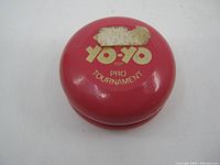 Top view of pink wooden Yo-Yo with gold lettering and partial sticker residue.