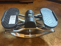 Top and front views of Bladez Fitness twist board stepper exercise equipment showing digital display and textured foot pedals.