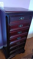Front view of seven-drawer mahogany lingerie dresser with brass bail-pull handles on each drawer