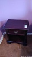 Front view of dark brown mahogany nightstand showing drawer and open shelf