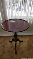 Full view of round cherry wood occasional table with tray-like top and tripod pedestal base.