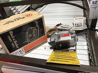 Photo showing the Black & Decker jig saw alongside its original box and a pack of saw blades.