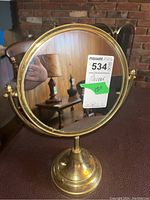 Front view of the metal stand mirror showing the reflective surface and metallic frame with the MaxSold tag.