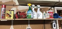 Wide shelf view showing Sears vice with wood refinishing solvents and garden chemicals arranged.