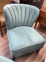 Front view of teal velour accent chair showing full profile and legs