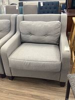 Front view of gray fabric upholstered armchair on wood floor