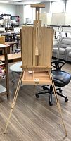 Full front view of assembled easel with closed storage panels and canvas support