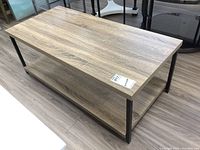 Full angle view of coffee table showing top and side metal frame supports.