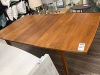 Front angle view of full dining table showing tabletop and tapered legs