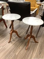 Two round marble top end tables side-by-side showing the tops and bases