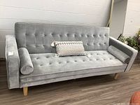 Full front view of grey velour futon with cushions