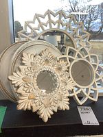 Wide view of all three decorative plastic framed wall mirrors grouped together showing their shapes, designs and colors.