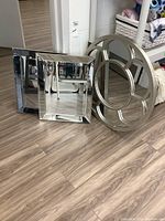 Photo showing three resin framed mirrors grouped on floor: two square mirrors with beveled edges and one round segmented frame mirror