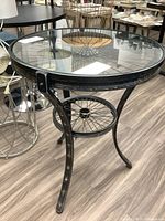 Full view of the table showing glass top, metal frame and legs.