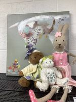 Full view of the canvas print with three plush toys displayed in front.