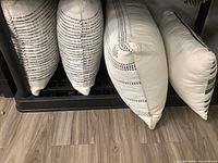 Four throw cushions arranged in a row showing side and front views with striped patterns and textures visible