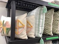 Photo of five decorative throw cushions on display, showing designs and arrangement