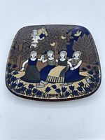 Top view of the square Arabia plate showing the folk art design with four women holding hands, tulips, trees, and date 1989.