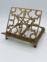 Front-side view of the brass stand with ornate cutout design and front ledge, showing the replacement brass bolt leg.