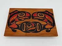 Top view of wooden tray showing red and black First Nations style painted design.