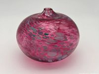 Photo showing the front and side angle of the pink and gray patterned glass bud vase with narrow top opening.