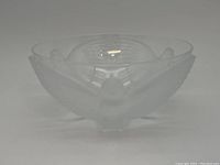Side view of frosted glass bowl showing bird relief design with outstretched wings.