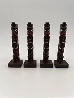 Four carved wooden Boma totem poles on square bases, approximately 5.5 inches tall each, shown standing side by side.