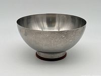 Side view of stainless steel bowl showing rounded shape, brushed exterior with spotting.