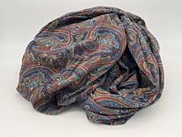 Rolled and folded paisley fabric showing pattern and colors.
