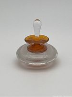 Side view of the signed Starfish Studios perfume bottle showing clear glass body with amber neck accent and stopper.