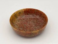 Top and inside view of the small stone bowl with natural reddish tones and marbled stone patterns.