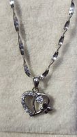 Close-up of the heart pendant on sterling silver twisted chain necklace.