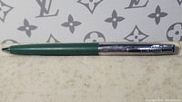 Full side view of the Sheaffer's pen showing green barrel and chrome cap with clip