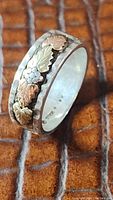 Photo of the tricolor gold Black Hills style ring showing detailed leaves and grapes on a 925 sterling silver band with hammered texture edges.