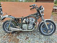 Left side view showing main motorcycle frame with engine, rear wheel, and exhaust.