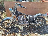 Side view of partially disassembled 1980 Yamaha XJ650G Maxim motorcycle frame showing engine, front wheel, rear wheel, and handlebars.