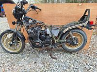 Side view of Yamaha motorcycle frame and parts showing gold wheels, exposed 4-cylinder engine, and missing body panels.