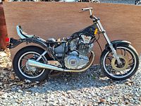 Full side view of 1984 Yamaha XS400 Maxim motorcycle frame showing engine, exhaust, wheels, and handlebars.