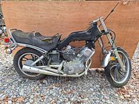 Side profile of 1984 Yamaha XV500 Virago motorcycle salvage with frame, engine, wheels, seat, and exhaust visible. Shows wear and condition of seat and body.