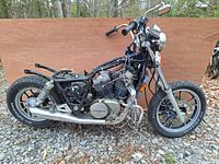 Left side view of incomplete motorcycle showing frame, engine and exhaust