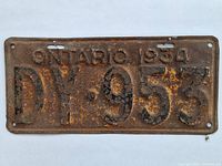 Front view of rusted 1934 Ontario license plate showing embossed characters and surface corrosion.