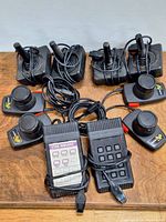 Two sets of Atari 2600 joysticks, paddles, and Star Raiders touch pads shown with cables.