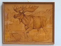 Wood burning artwork on maple veneer featuring a moose in natural setting, framed and under glass.