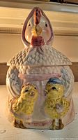 Front view of vintage mother hen cookie jar showing detailed painting and two chicks at front