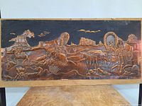 Full front view of embossed copper artwork showing pioneer settlers with covered wagons and desert landscape