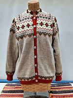 Front view of the Viking Knit sweater on mannequin showing detailed knit pattern, buttons, and red trim.