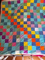 Full view of the colorful patchwork quilt front showing multicolored squares sewn together.