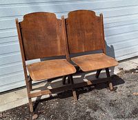 Front view of the wooden two-seat flip-up bench showing both seats down revealing the solid wood backs and seats.