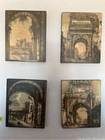 Four sepia toned plaques depicting arches and ruins, arranged in a grid on white wall.
